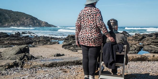 Opiekunka z seniorem na wózku inwalidzkim - nad morzem